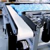 Two conveyors transferring plastic parts 90-degrees